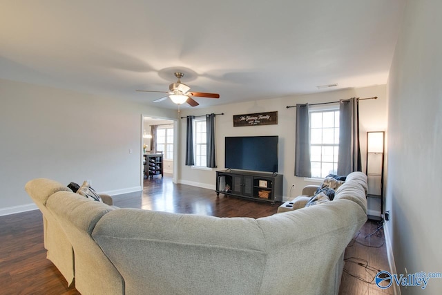 living room featuring ceiling fan, dark hardwood / wood-style floors, and a healthy amount of sunlight