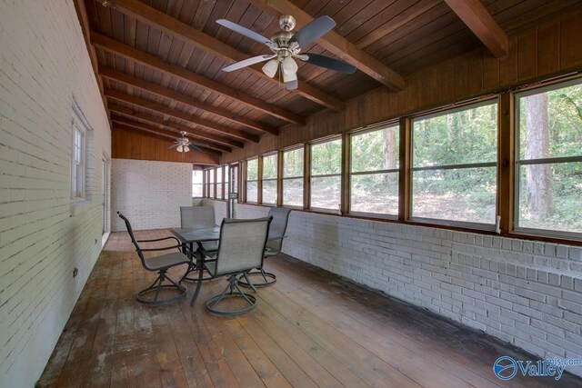 unfurnished sunroom featuring wood ceiling, ceiling fan, and vaulted ceiling with beams