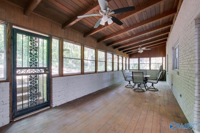 unfurnished sunroom featuring ceiling fan, vaulted ceiling with beams, and wooden ceiling