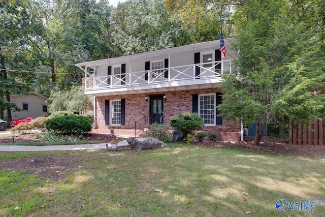 view of front facade with a balcony and a front lawn