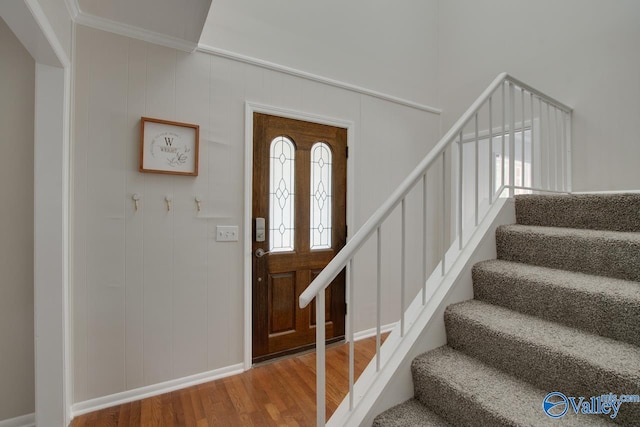 foyer with a wealth of natural light, ornamental molding, and wood-type flooring