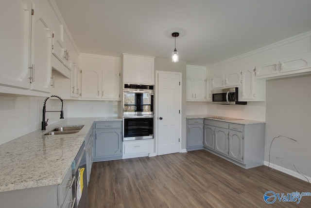 kitchen with pendant lighting, sink, stainless steel appliances, and white cabinets