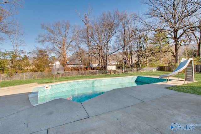 view of swimming pool featuring a yard, a patio, and a water slide