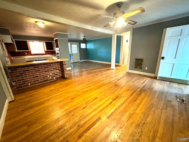 unfurnished living room featuring ceiling fan and light wood-type flooring