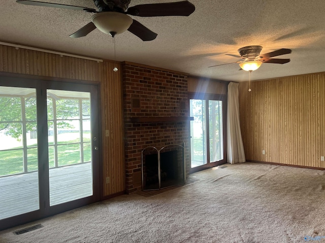 unfurnished living room with a textured ceiling, visible vents, and ceiling fan