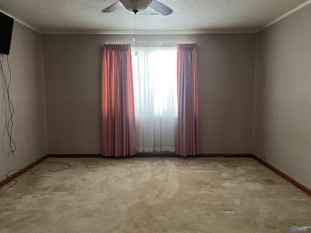 carpeted spare room featuring baseboards, ceiling fan, crown molding, and a textured ceiling