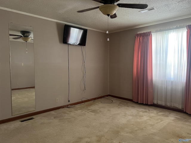 spare room featuring ornamental molding, visible vents, and ceiling fan