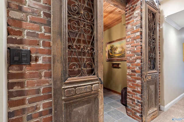 interior space featuring wooden ceiling, carpet, and brick wall