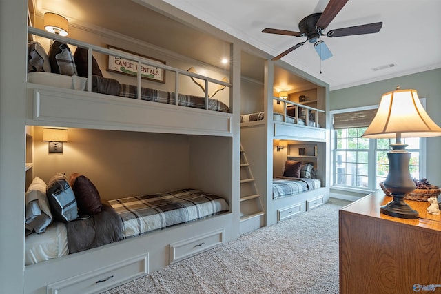 carpeted bedroom featuring ceiling fan and crown molding