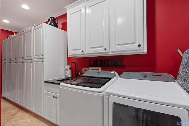 laundry room featuring washing machine and dryer, cabinets, and ornamental molding