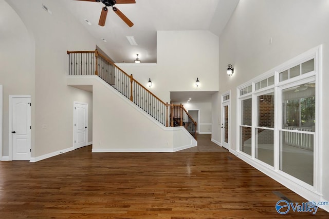 118 Conservancy Dr, Madison, AL 35758 - unfurnished living room featuring high vaulted ceiling, a ceiling fan, stairs, and wood finished floors
