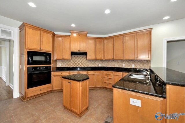 118 Conservancy Dr, Madison, AL 35758 - kitchen with black appliances, under cabinet range hood, dark stone countertops, a center island, and backsplash