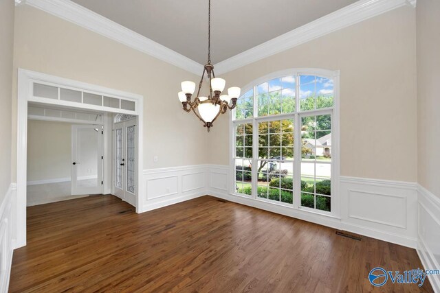 118 Conservancy Dr, Madison, AL 35758 - unfurnished dining area featuring plenty of natural light, a chandelier, a decorative wall, crown molding, and a wainscoted wall