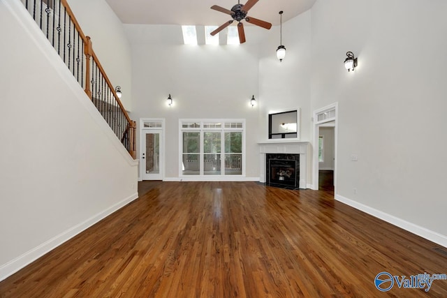 118 Conservancy Dr, Madison, AL 35758 - unfurnished living room with ceiling fan, a high end fireplace, wood finished floors, stairs, and a towering ceiling