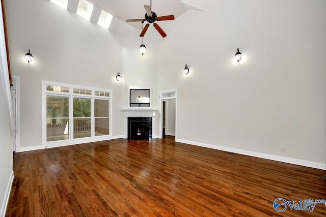 118 Conservancy Dr, Madison, AL 35758 - unfurnished living room featuring a high ceiling, wood finished floors, ceiling fan, and a fireplace with flush hearth
