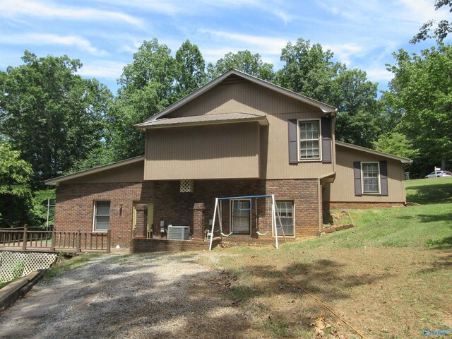 109 Colonial Dr, Scottsboro, AL 35768 - rear view of house featuring central air condition unit, a yard, a wooden deck, and brick siding