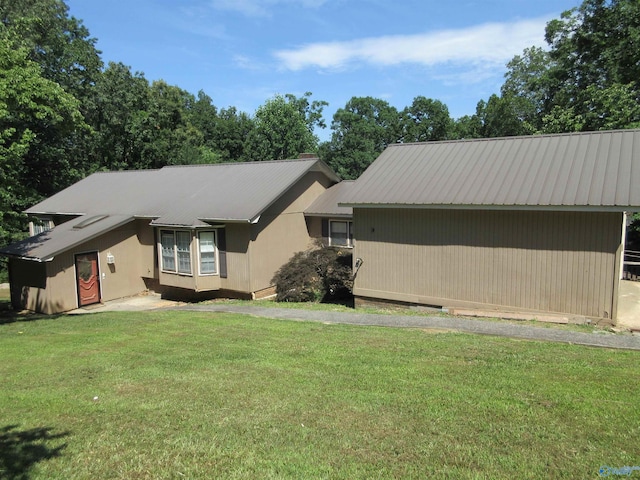 view of home's exterior with metal roof and a yard