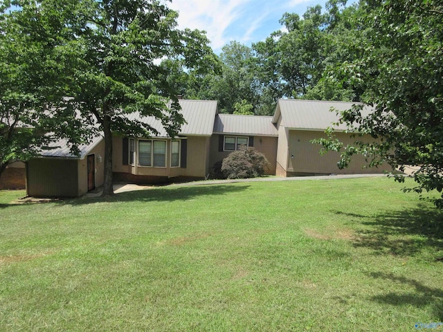 ranch-style home with a front yard and metal roof