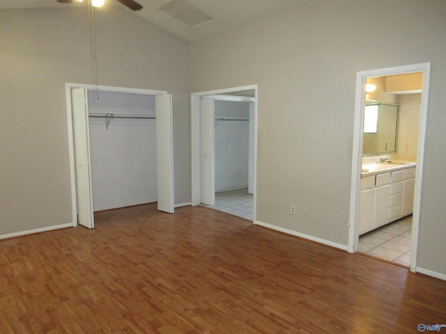 109 Colonial Dr, Scottsboro, AL 35768 - unfurnished bedroom with connected bathroom, a sink, two closets, and light wood-style floors