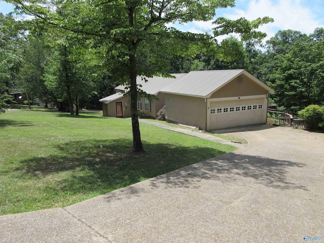 109 Colonial Dr, Scottsboro, AL 35768 - view of front of home featuring a garage, concrete driveway, metal roof, a front yard, and stucco siding