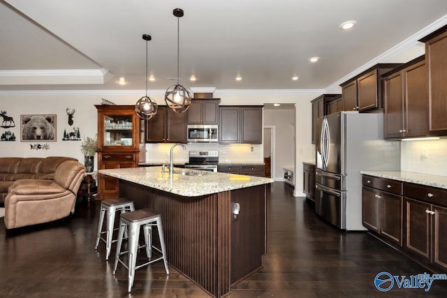 kitchen with stainless steel appliances, hanging light fixtures, sink, and dark brown cabinets