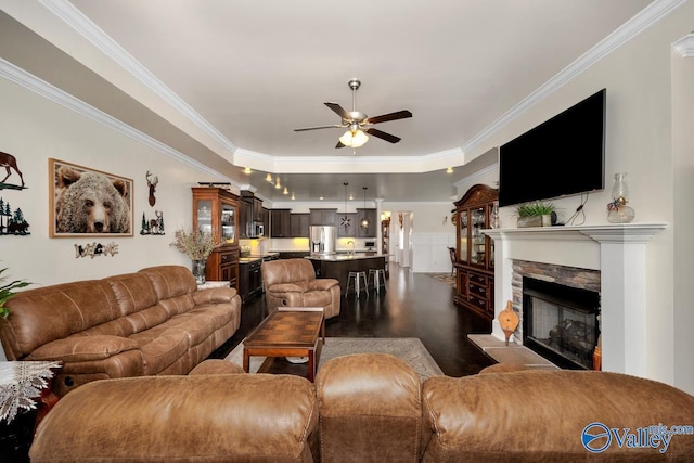 living room featuring dark wood-type flooring, ceiling fan, and ornamental molding