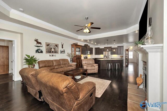 living room featuring crown molding, ceiling fan, and dark hardwood / wood-style flooring