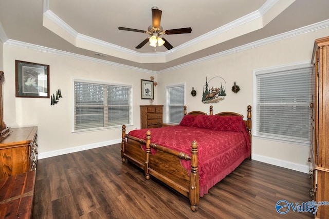 bedroom featuring dark wood-type flooring, a tray ceiling, and crown molding