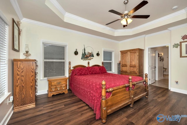 bedroom with crown molding, ceiling fan, dark hardwood / wood-style flooring, and a tray ceiling