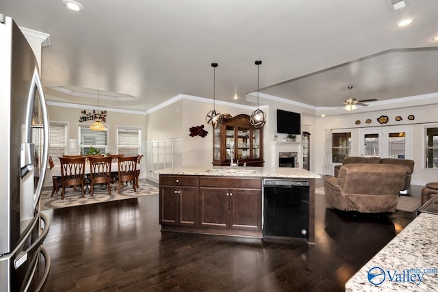 kitchen featuring hanging light fixtures, stainless steel refrigerator, a tray ceiling, dishwasher, and light stone countertops