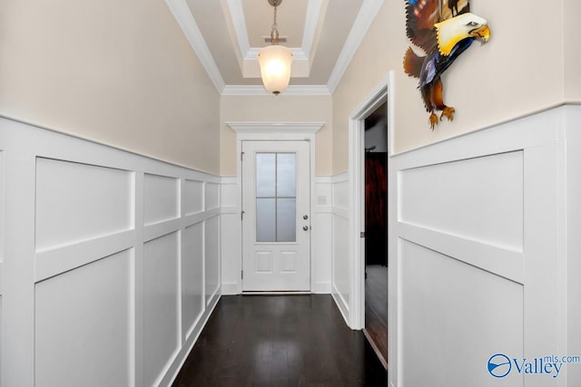 doorway to outside featuring dark wood-type flooring, ornamental molding, and a tray ceiling