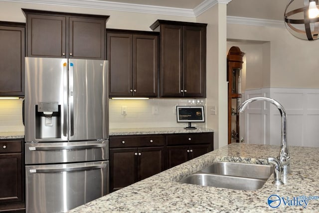 kitchen featuring stainless steel refrigerator with ice dispenser, dark brown cabinets, sink, and crown molding