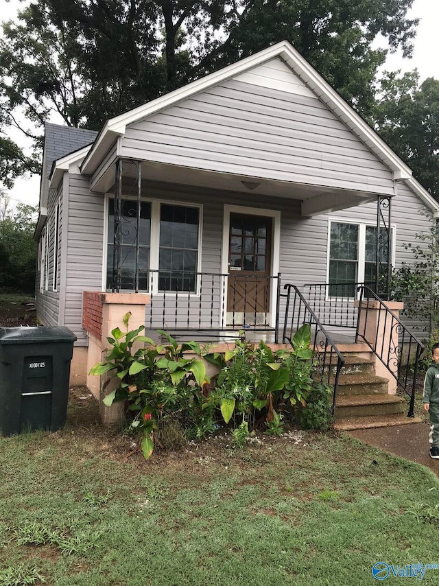 bungalow-style home featuring a porch and a front yard