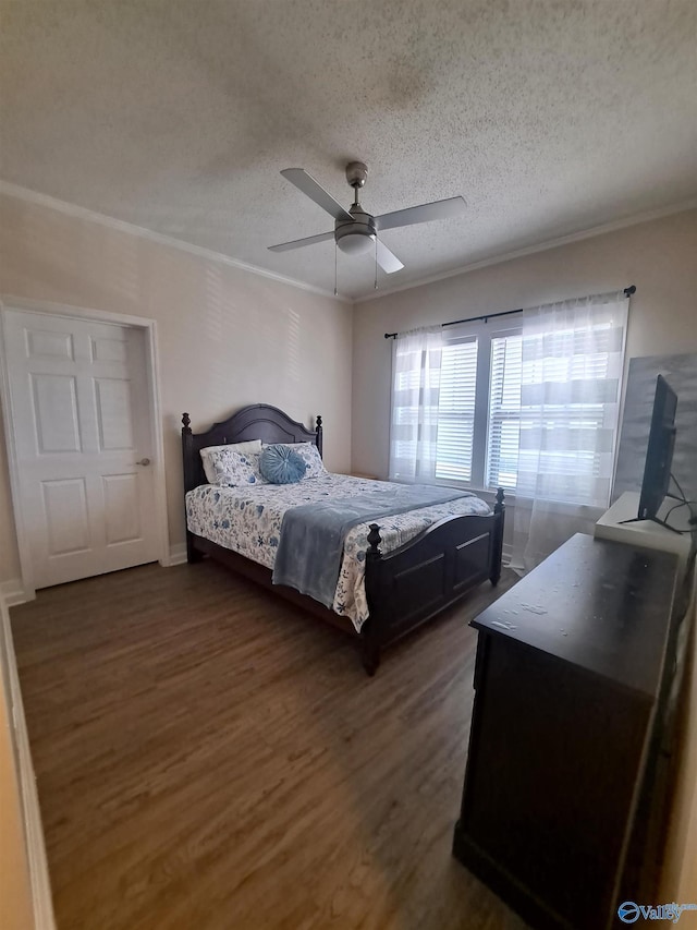 bedroom featuring ceiling fan, crown molding, dark wood-style floors, and a textured ceiling