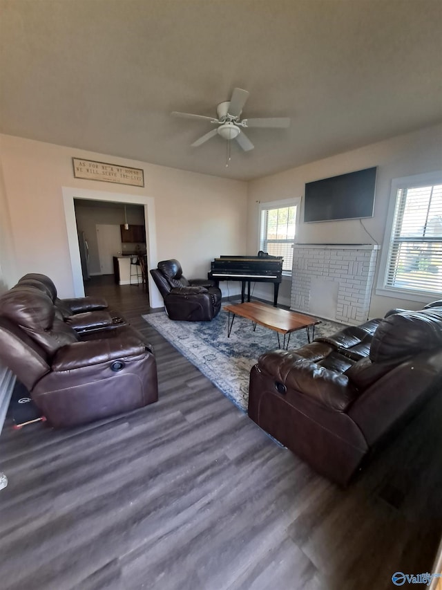 living room with a ceiling fan, wood finished floors, and a fireplace