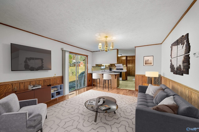 living room featuring wood walls, crown molding, and light hardwood / wood-style flooring