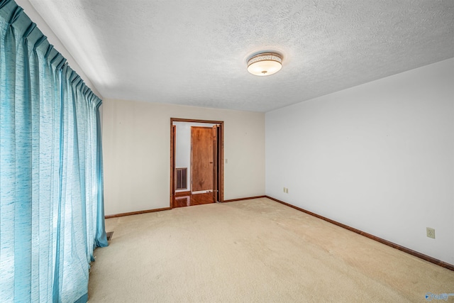 unfurnished room with carpet floors and a textured ceiling