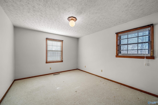 carpeted spare room with a textured ceiling