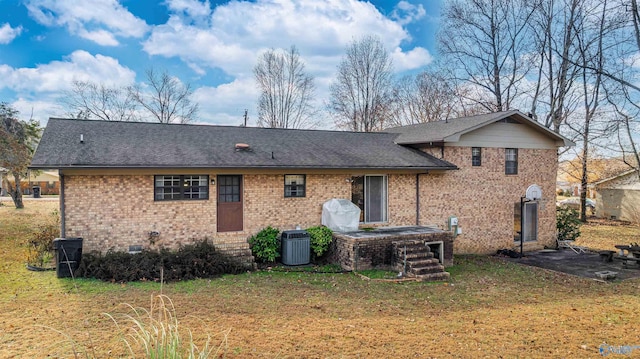 back of house with central AC and a yard