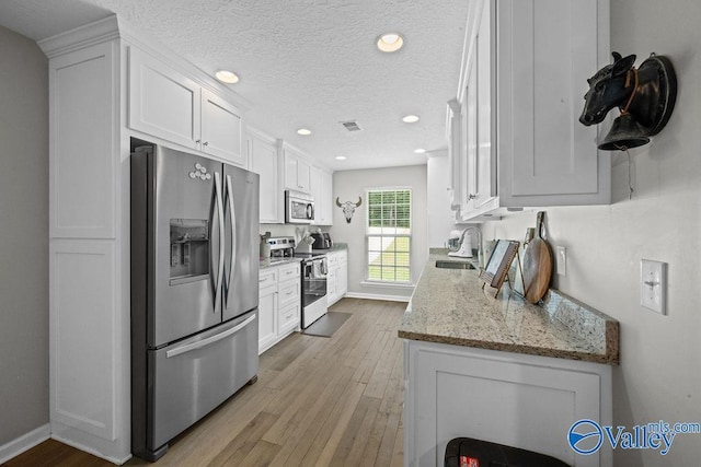 713 Rabbittown Rd, Glencoe, AL 35905 - kitchen featuring stainless steel appliances, wood-type flooring, white cabinets, recessed lighting, and a sink