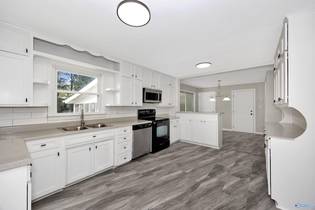 2501 Andrew Jackson Way NE, Huntsville, AL 35811 - kitchen with a peninsula, a sink, backsplash, open shelves, and appliances with stainless steel finishes
