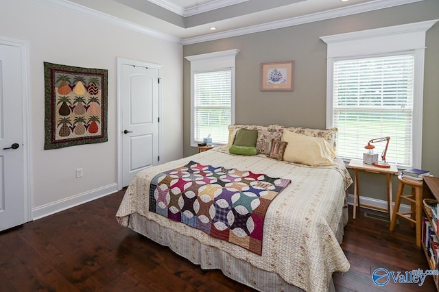 bedroom with ornamental molding, dark hardwood / wood-style floors, and a raised ceiling