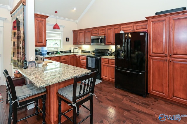 kitchen featuring pendant lighting, black appliances, a breakfast bar area, ornamental molding, and kitchen peninsula