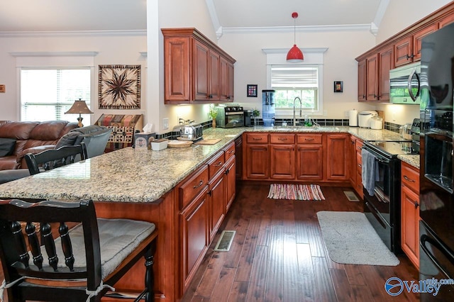 kitchen featuring black electric range oven, sink, a kitchen breakfast bar, ornamental molding, and kitchen peninsula