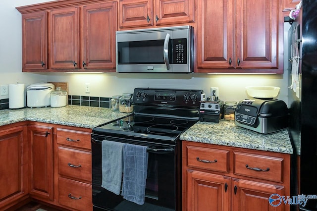 kitchen with light stone countertops and black appliances