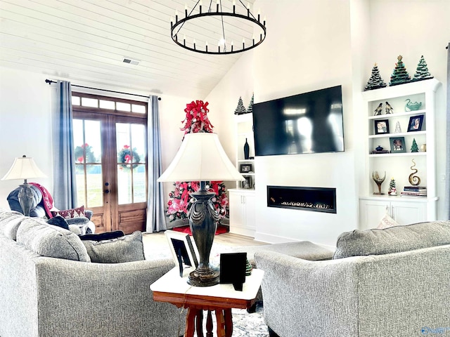 living room featuring vaulted ceiling, built in shelves, french doors, and wooden ceiling