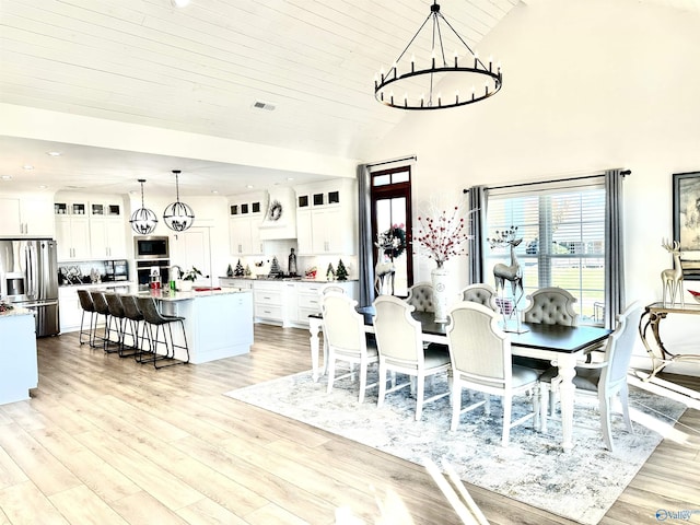 dining room with high vaulted ceiling, a notable chandelier, light wood-type flooring, and wood ceiling