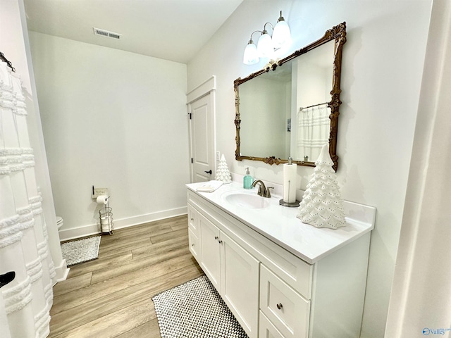 bathroom featuring toilet, wood-type flooring, and vanity