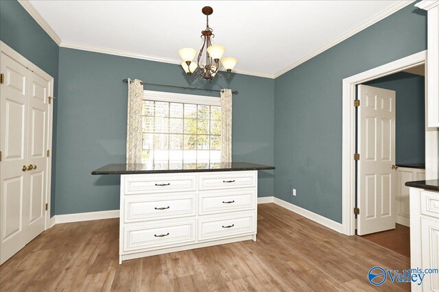 unfurnished dining area featuring an inviting chandelier, crown molding, and light wood-type flooring