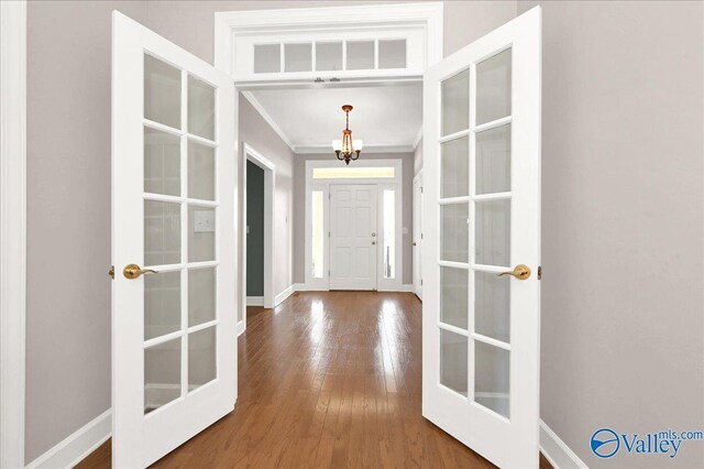 entryway featuring crown molding, wood-type flooring, and french doors